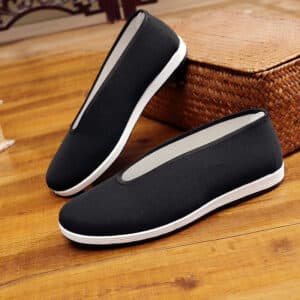 chaussures traditionnelles de kung fu noires sur parquet marron