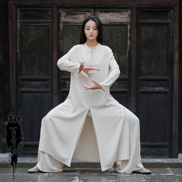 femme avec les cheveux longs et détachés, portant un uniforme traditionnel de kung fu beige , ses jambes sont pliées et ecartées, ses bras rapprochés devant son buste comme si elle tenait quelque chose entre ses mains