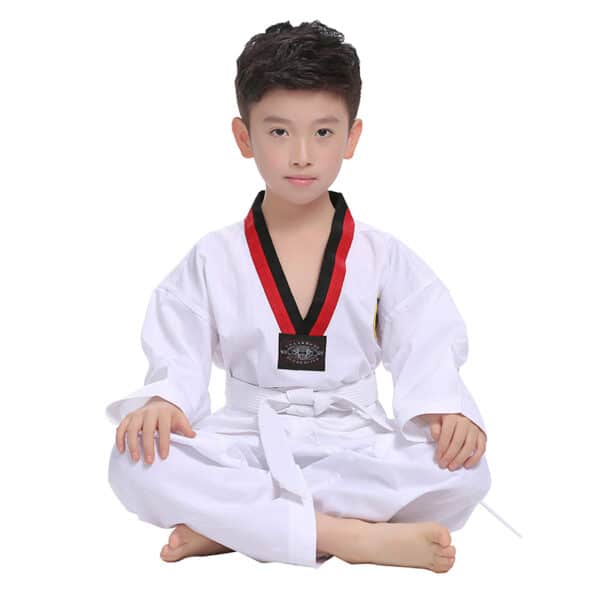 Jeune garçon habillé d'un kimono pour la pratique d'arts martiaux, se tient assis en tailleur, présenté sur fond blanc