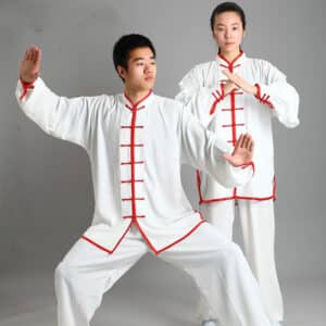 un homme et une femme portent le m^me ensemble de kung fu ou de tai chi en blanc avec les couture de couleur rouge, l'homme est en position de combat, la femme se tient debout avec les mains jointes