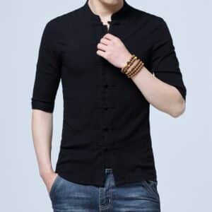 Jeune homme dont on ne voit pas le visage, porte une chemise traditionnelle chinoise noire à la mode pour hommes, il touche un des boutons avec sa main