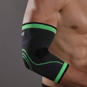 Protège-coude noir et vert pour boxe en nylon sur un bras d'un homme torse nu sur fond gris