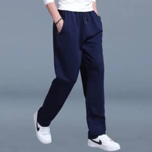 Pantalon Full Contact Effet Jambe Large pour Homme porté par un homme avec des baskets et un t-shirt blanc sur fond bleu