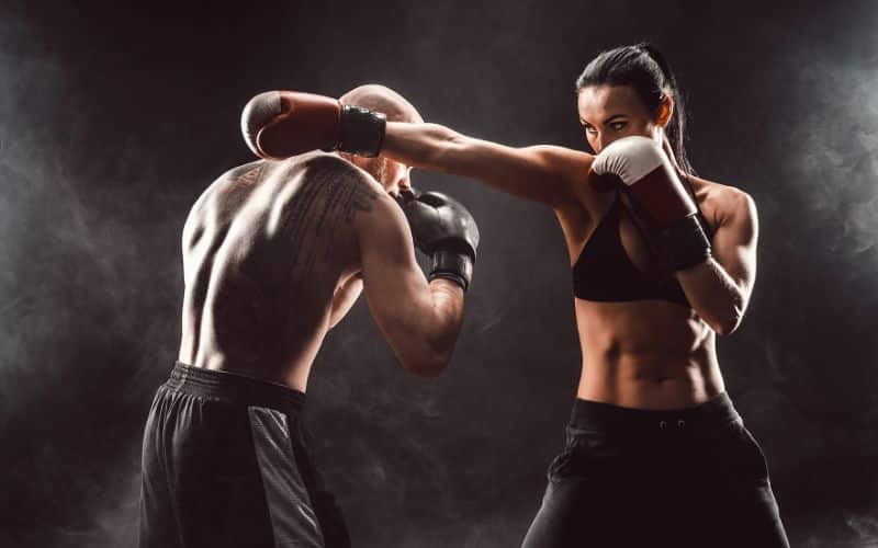 Duo homme, femme en short noir de boxe et brassière pour madame, avec des gants, pratiquant la boxe.